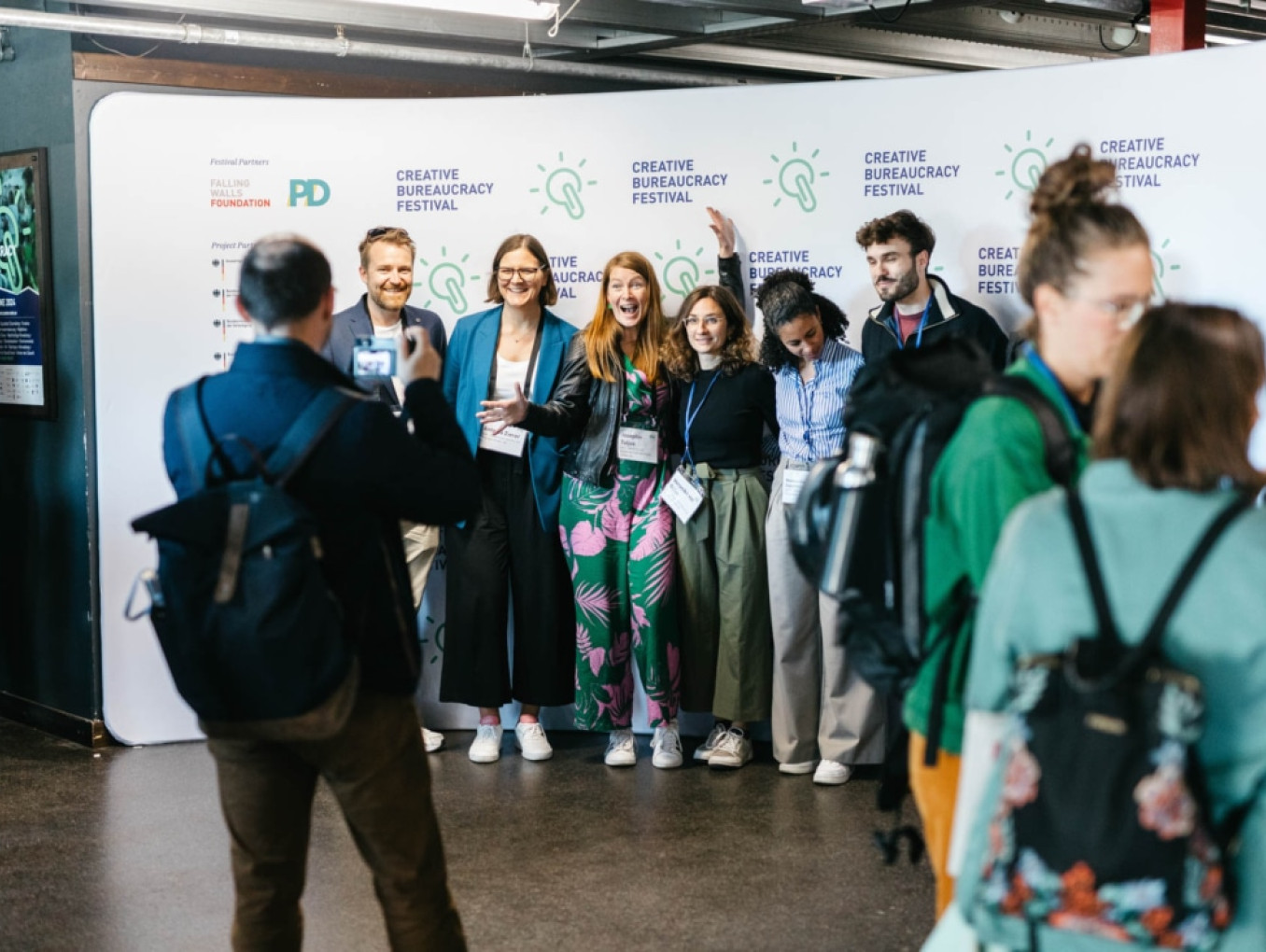 a group of people standing infront of the photo wall