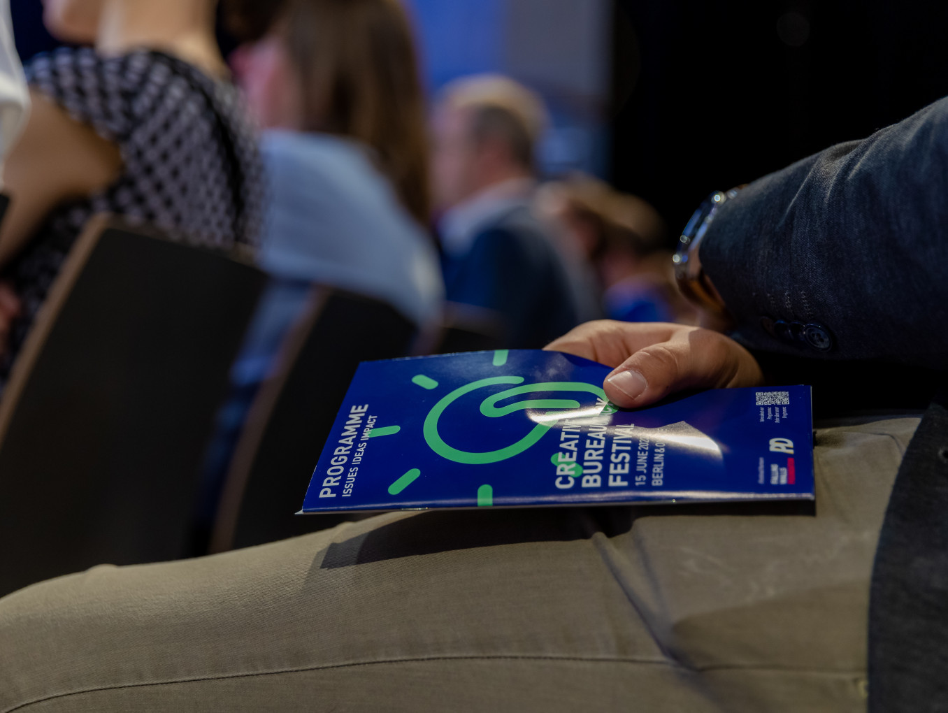 person sitting in the audience has the programme calendar in their hands 