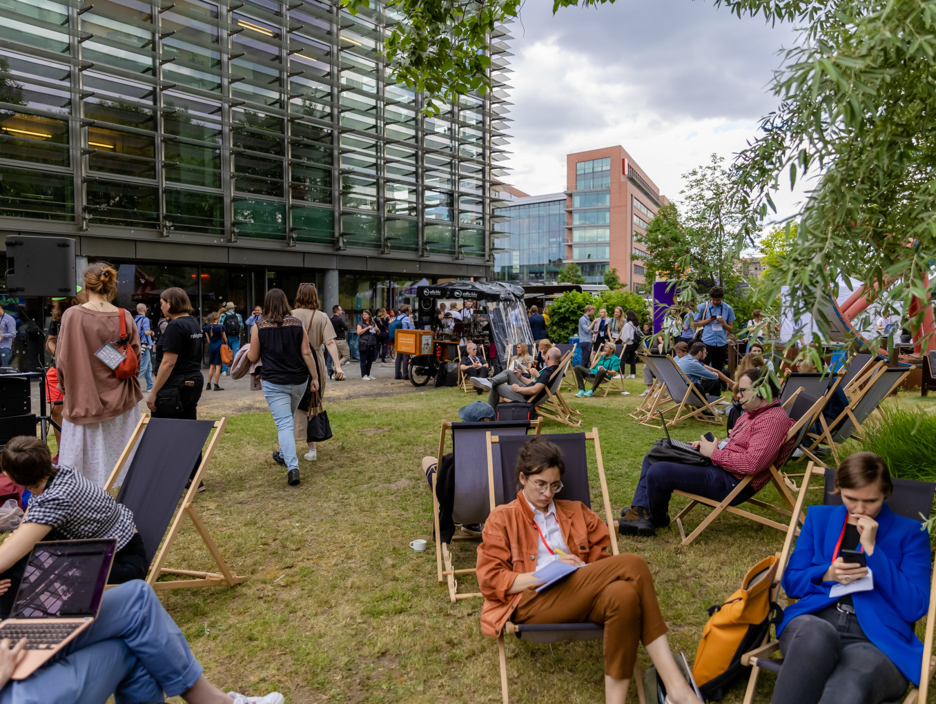 outside area of the festival 2023, people sitting, walking outside, networking and working 
