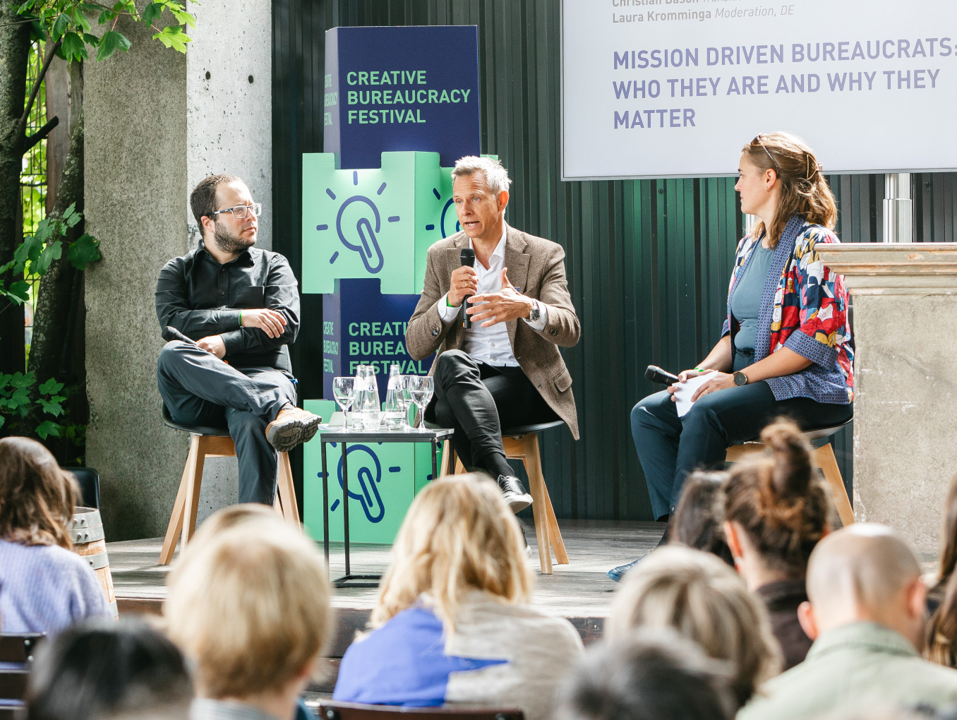 Drei Speaker halten eine Präsentation und sitzen auf der Connection Stage des Festivals