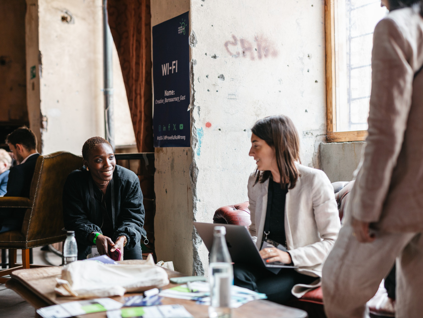two woman talking and smiling next to each other 