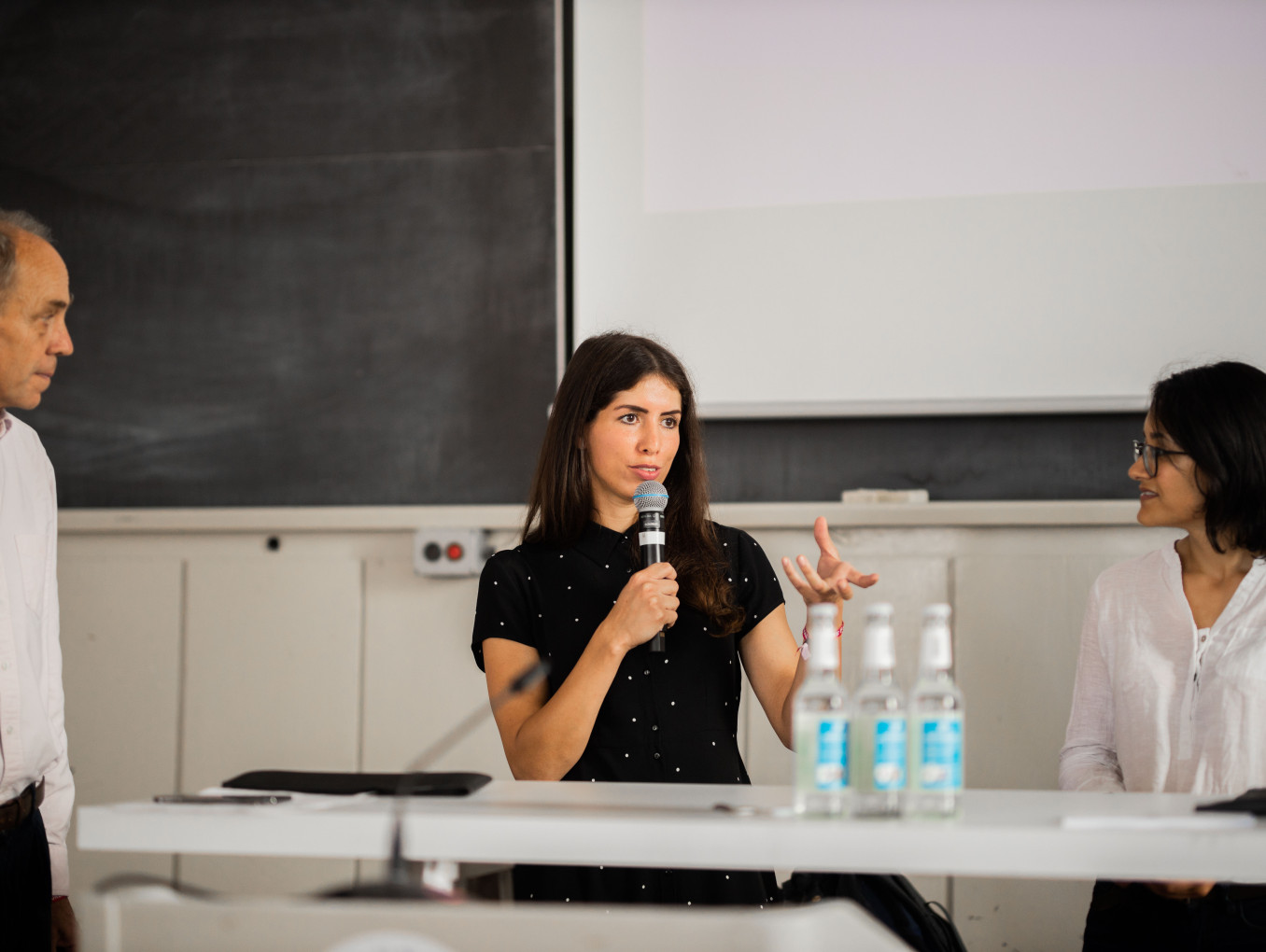 female speaker talking and two other people listening 