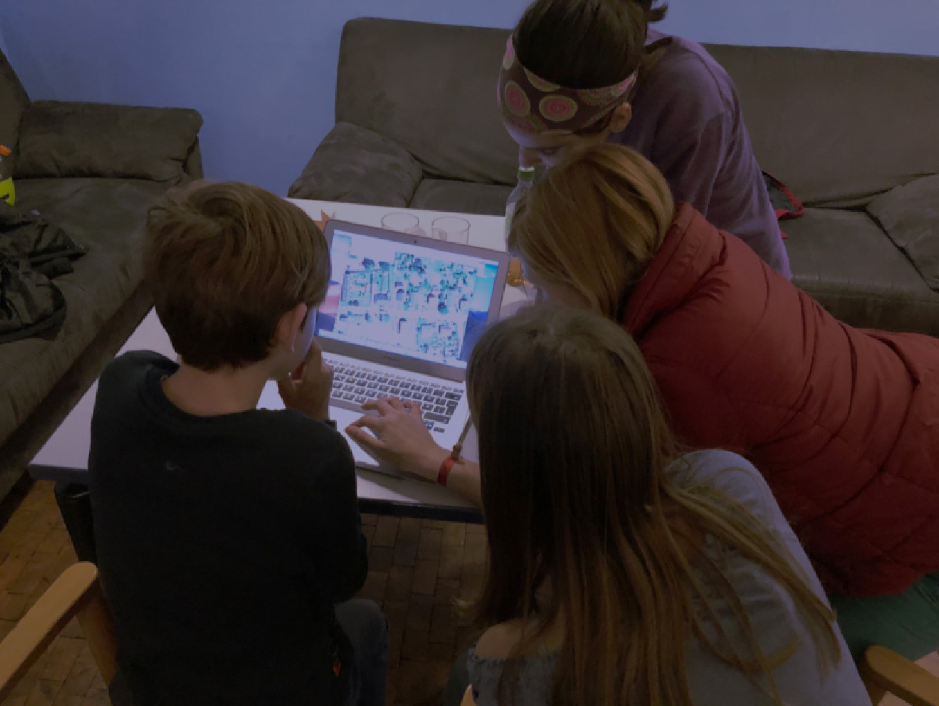 3 kids looking at a laptop 