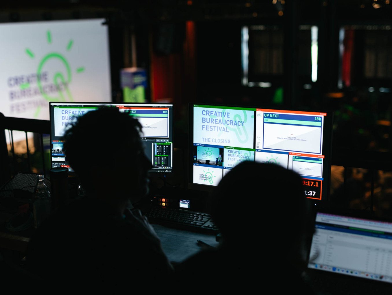 Two people sitting in front of computer screens