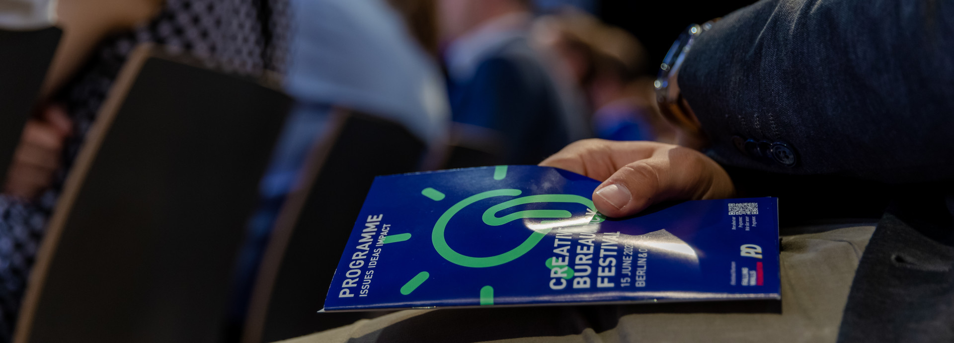person sitting in the audience has the programme calendar in their hands 