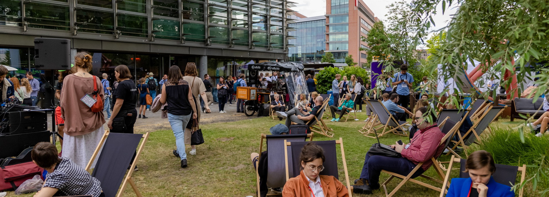 outside area of the festival 2023, people sitting, walking outside, networking and working 
