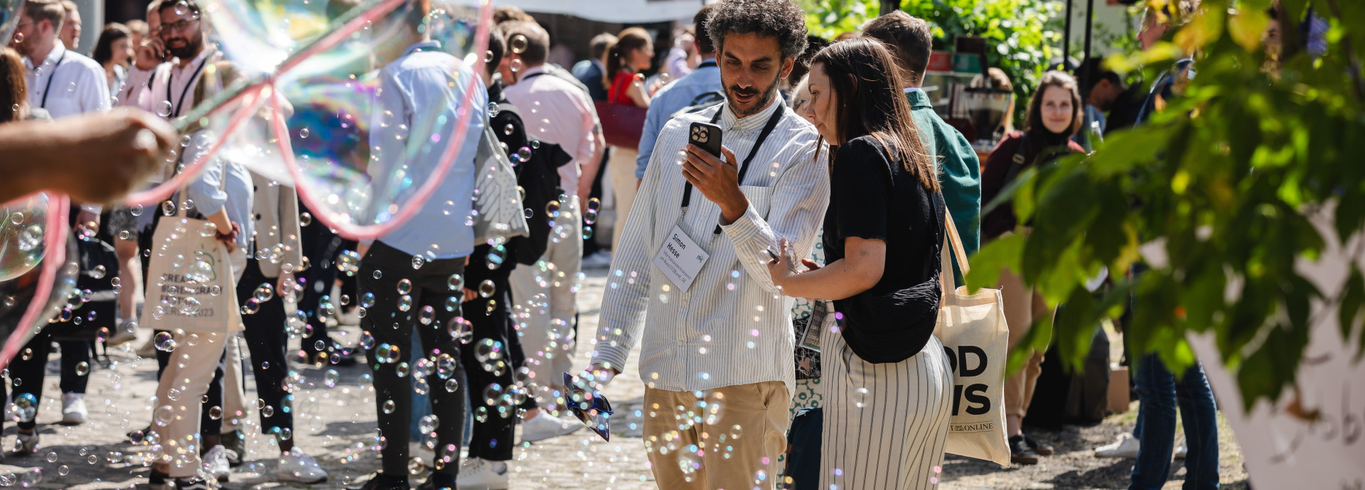 festival area outside, people standing, talking and you can see air bubbles 