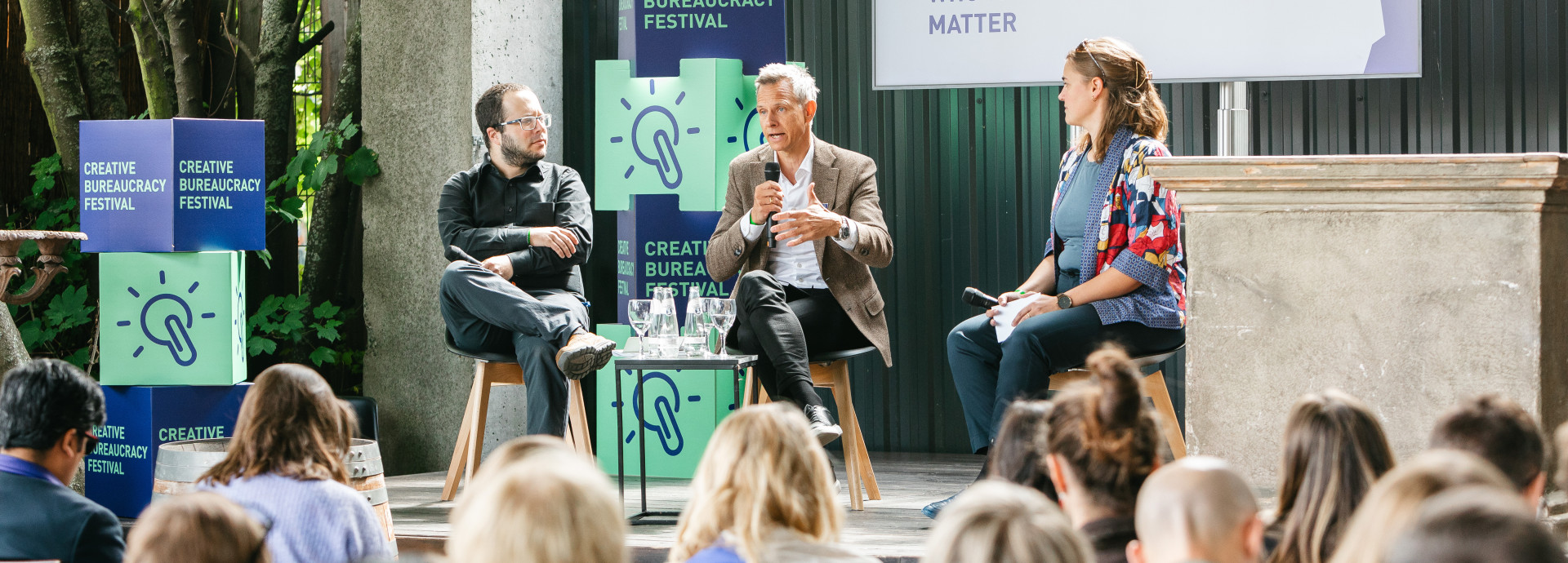 3 speakers holding a presentation sitting on the connection stage at the festival 