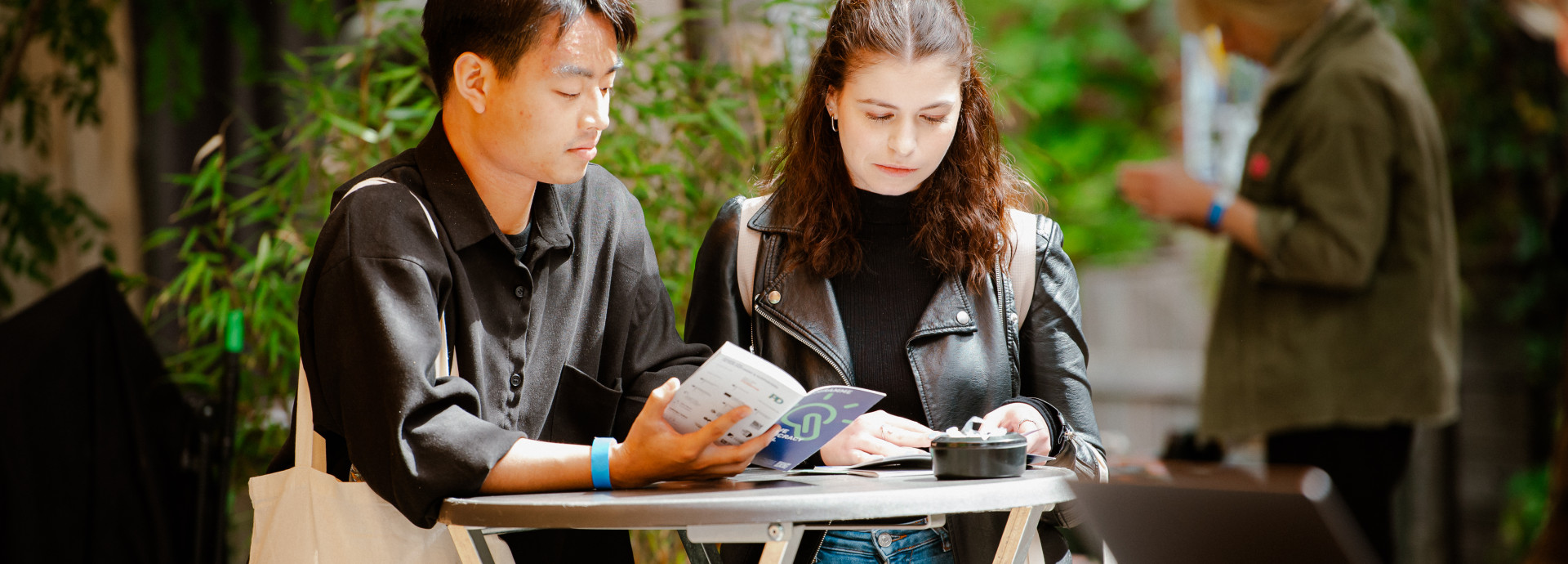 two young people reading the programme of the festival 