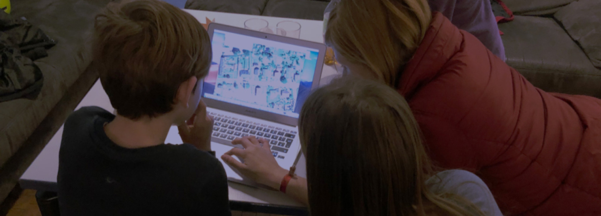 3 kids looking at a laptop 