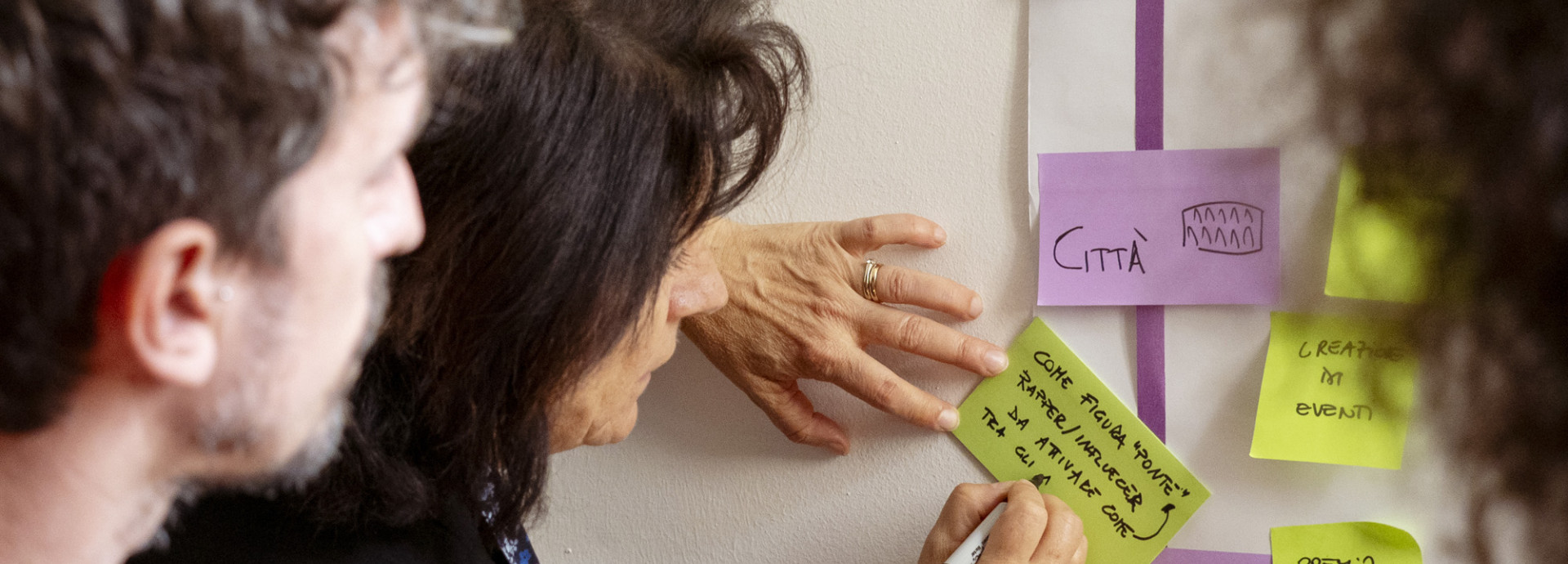 people attending a workshop, writing on post its 