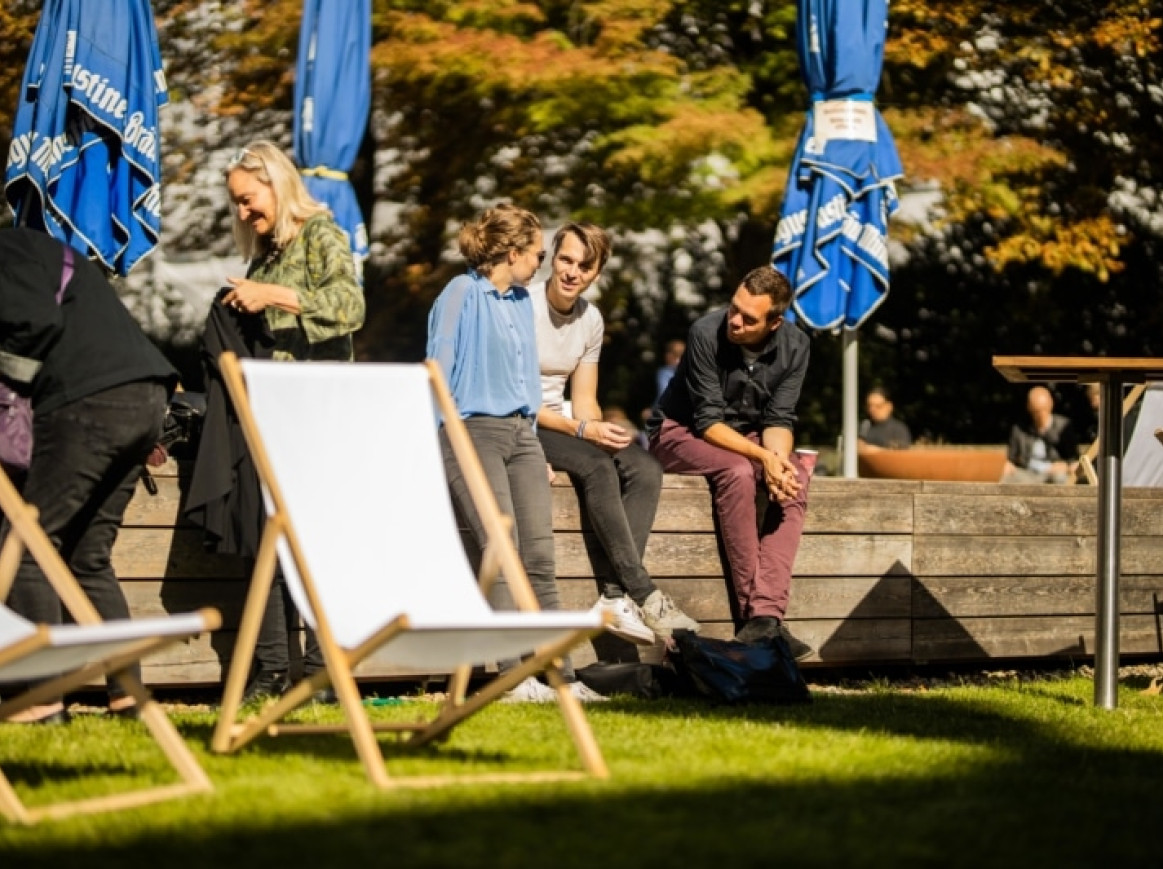 outside area of the festival, people talking and sitting in the sun 