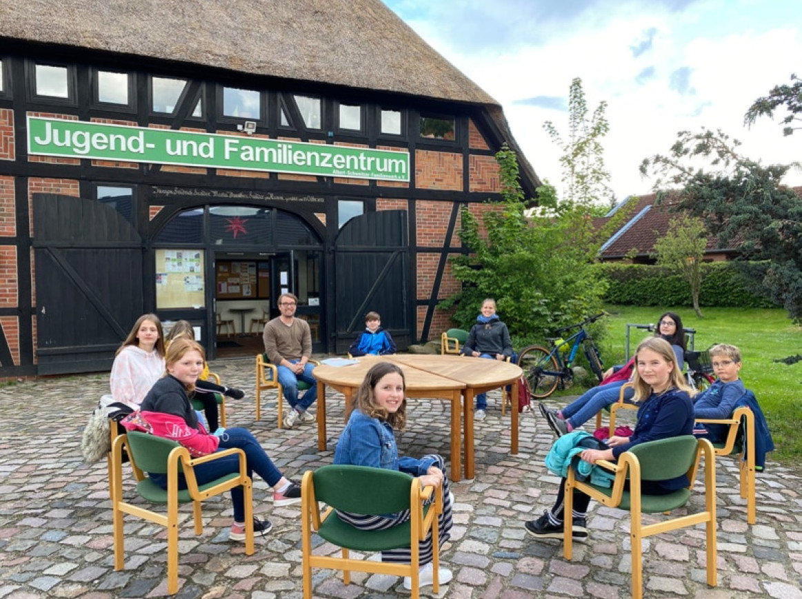 kids sitting outside on a round table 
