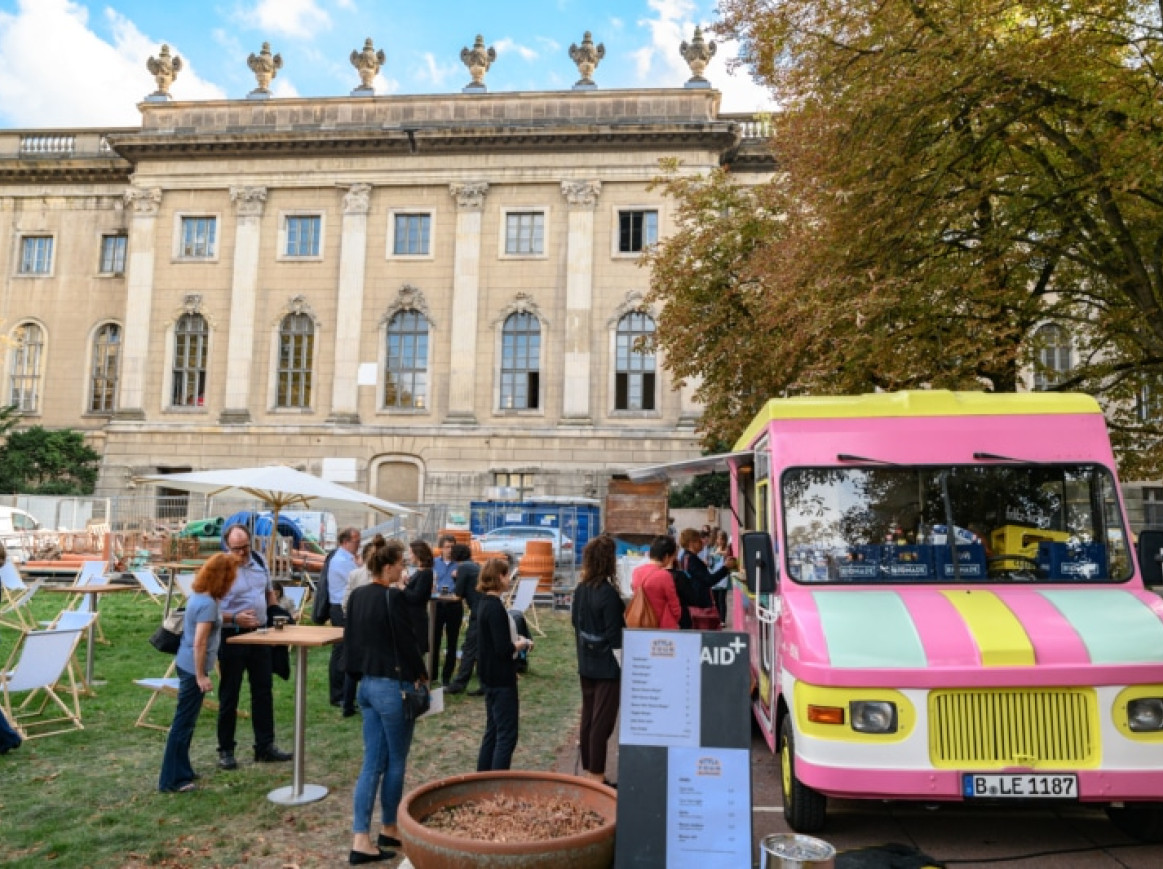 food truck outside of the festival area and people standing outside 