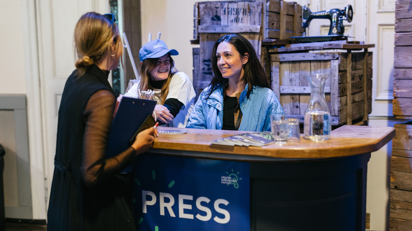 press counter at the festival, 3 woman having a conversation