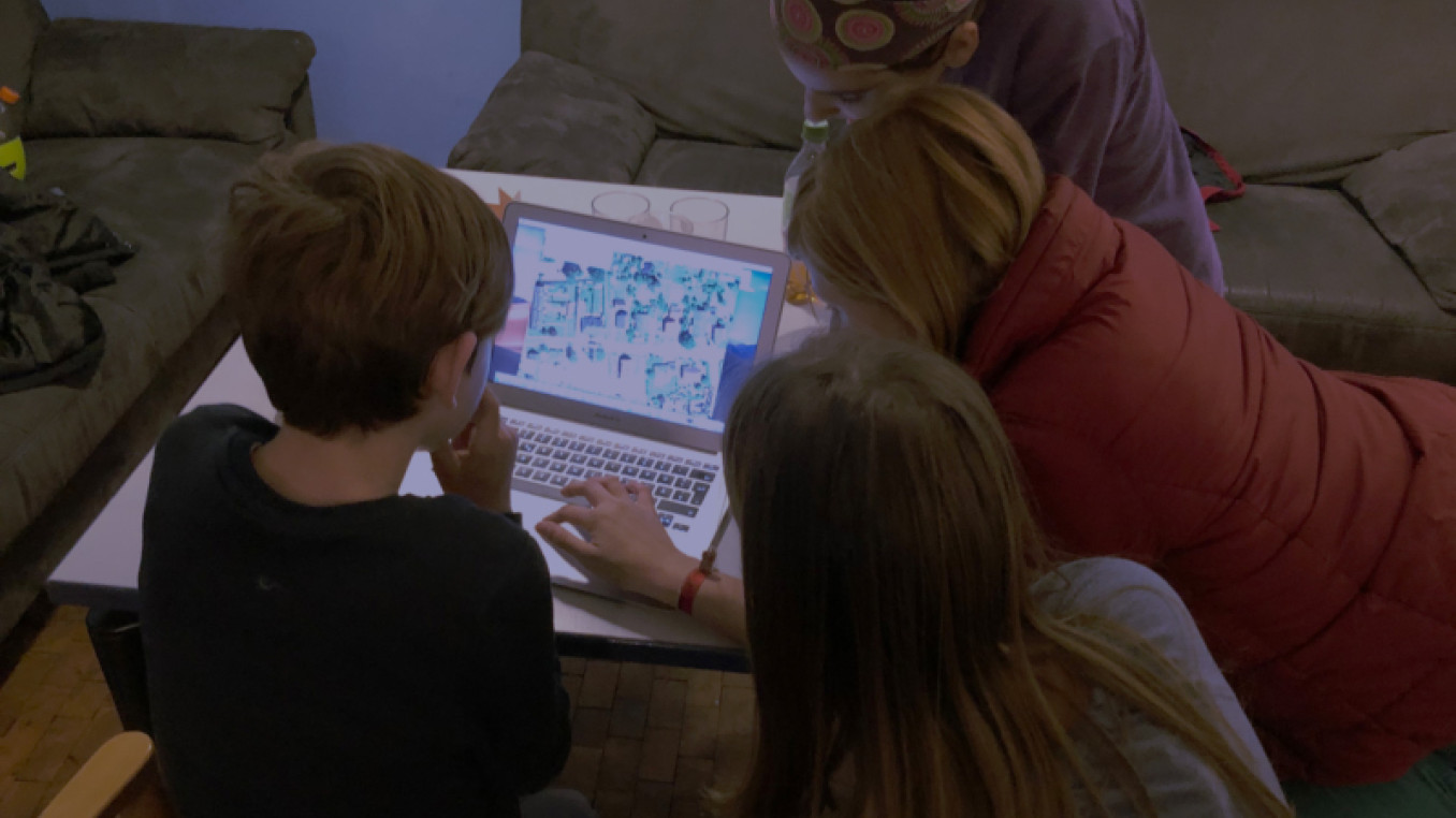 3 kids looking at a laptop 