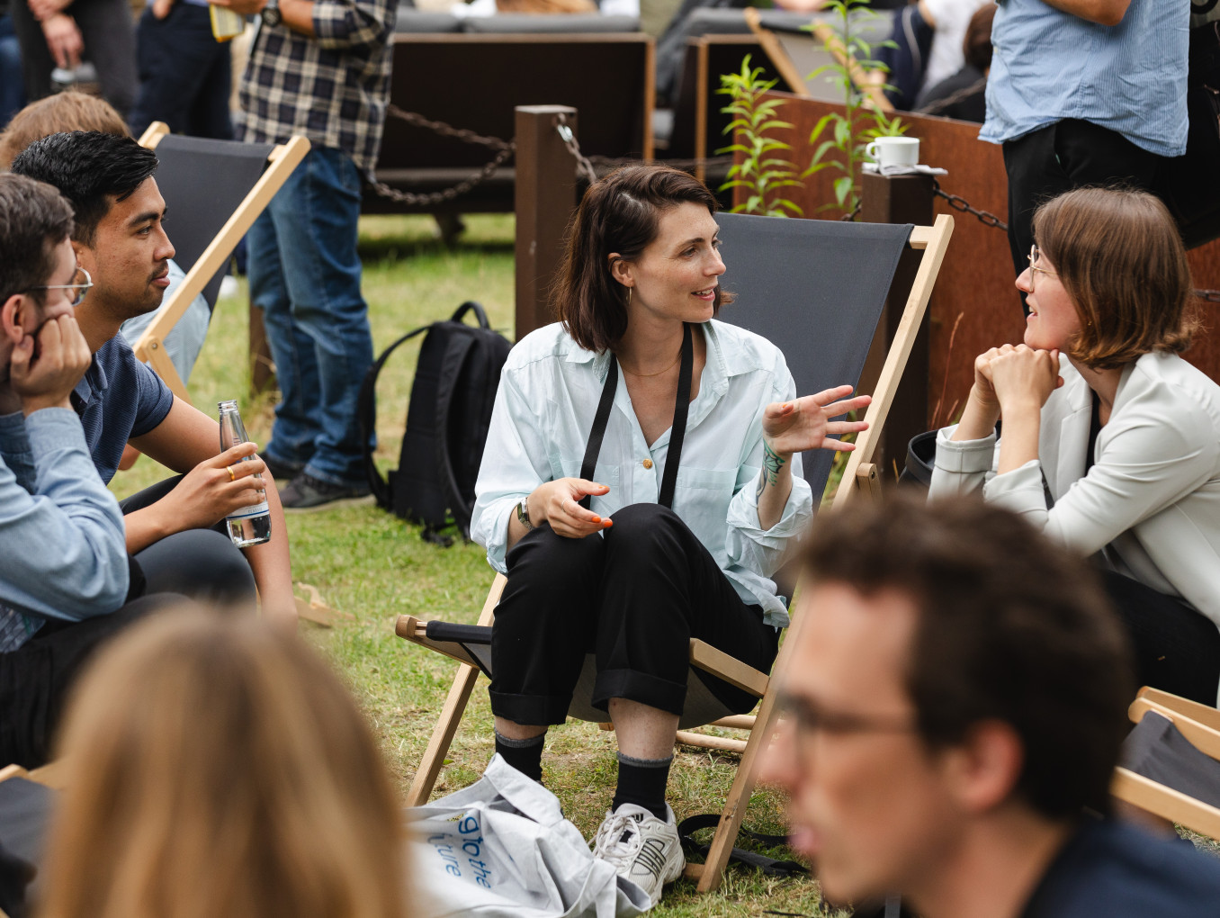 different people sitting in chairs in a circle and talking to each other