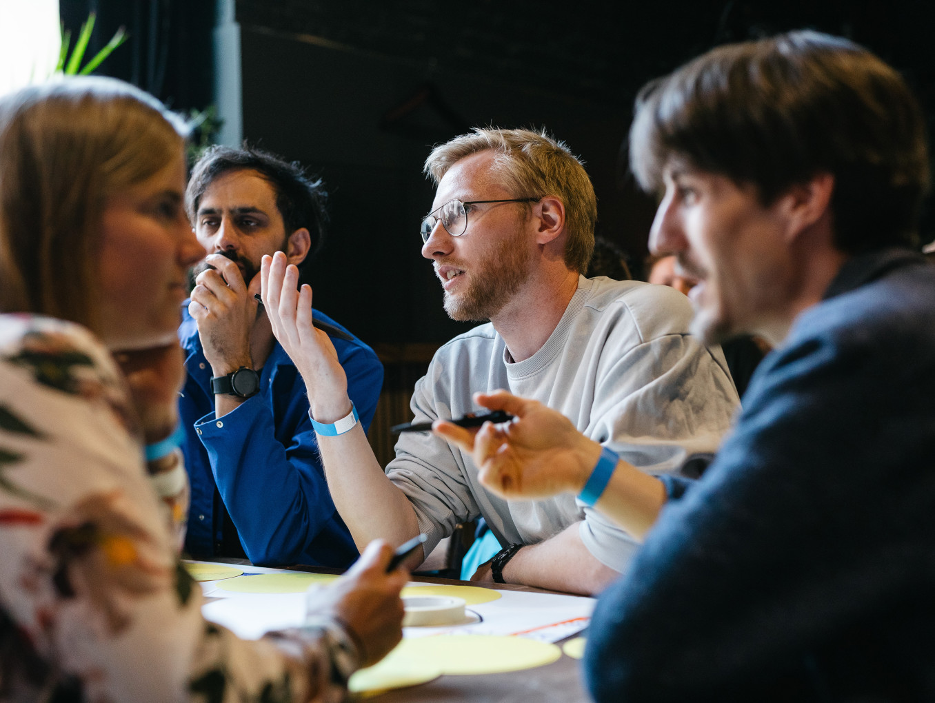 4 people sitting on a table discussing ideas