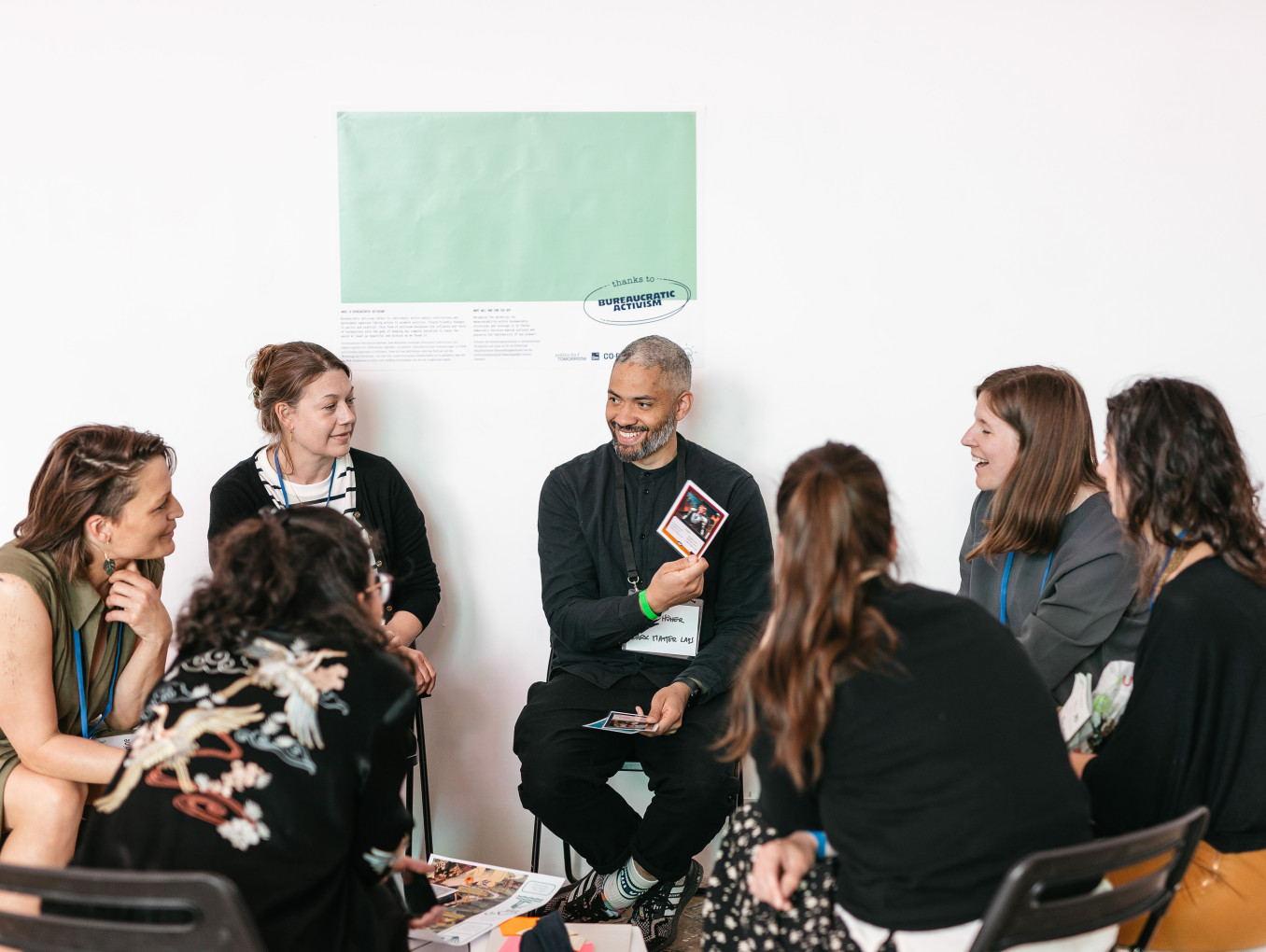 Menschen sitzen im Kreis, reden und lächeln
