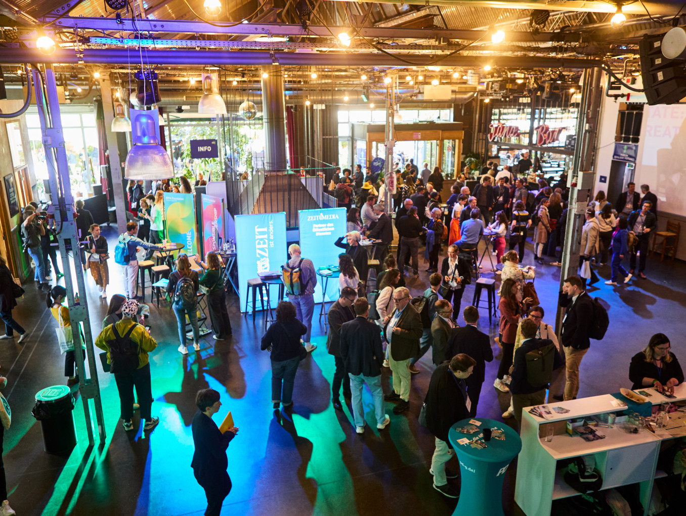 Networking-Bereich beim Festival, viele Menschen laufen herum und unterhalten sich miteinander