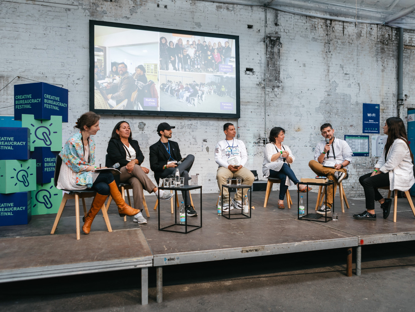 seven speaker sitting on stage and having a discussion