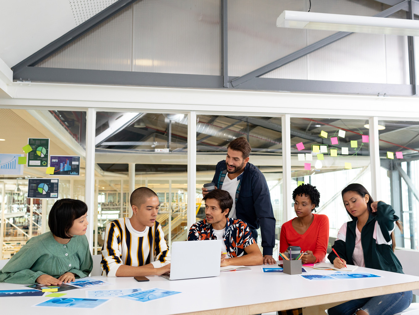 people sitting on a desk in an office working together