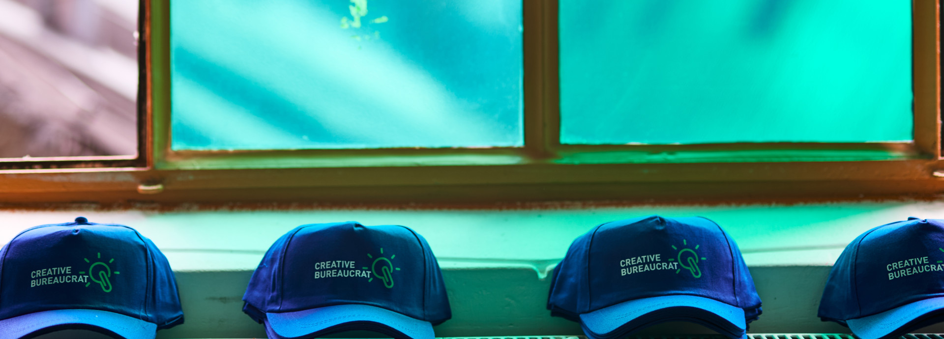 Creative Bureaucracy Festival-Merch (4 Caps) auf einem Heizkörper