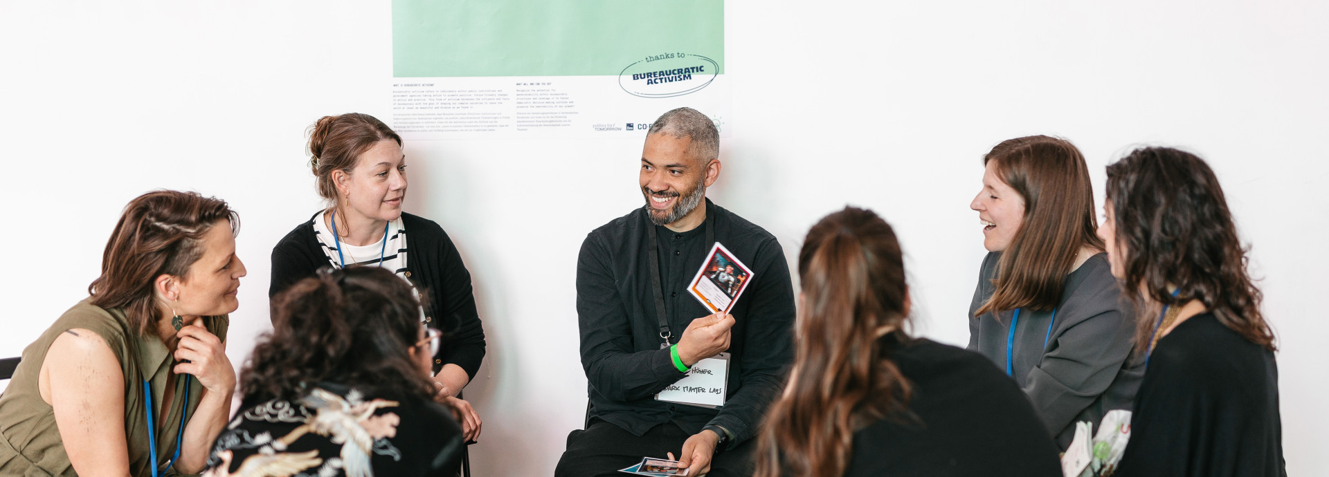 Menschen sitzen im Kreis, reden und lächeln