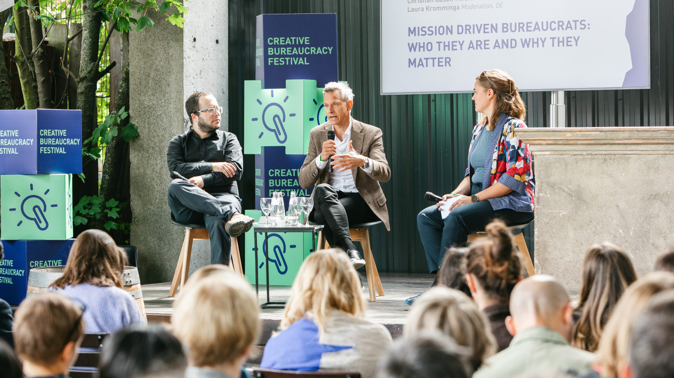 3 speakers holding a presentation sitting on the connection stage at the festival
