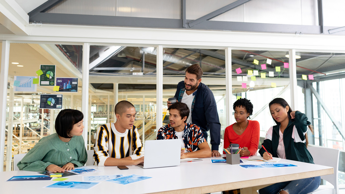 people sitting on a desk in an office working together 